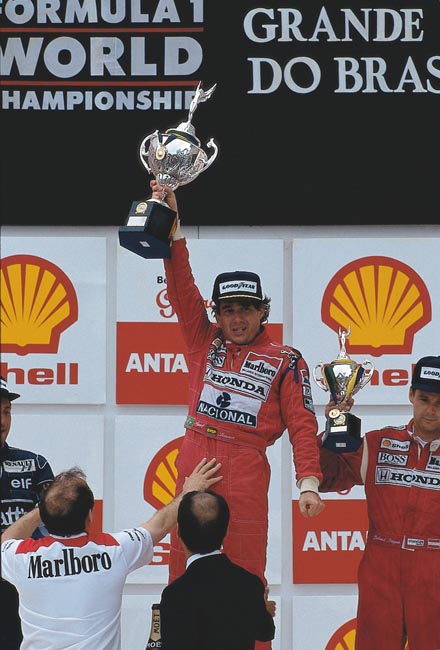 A historica foto de Ayrton Senna a erguer, com dificuldades, o troféu da vitoria no GP do Brasil